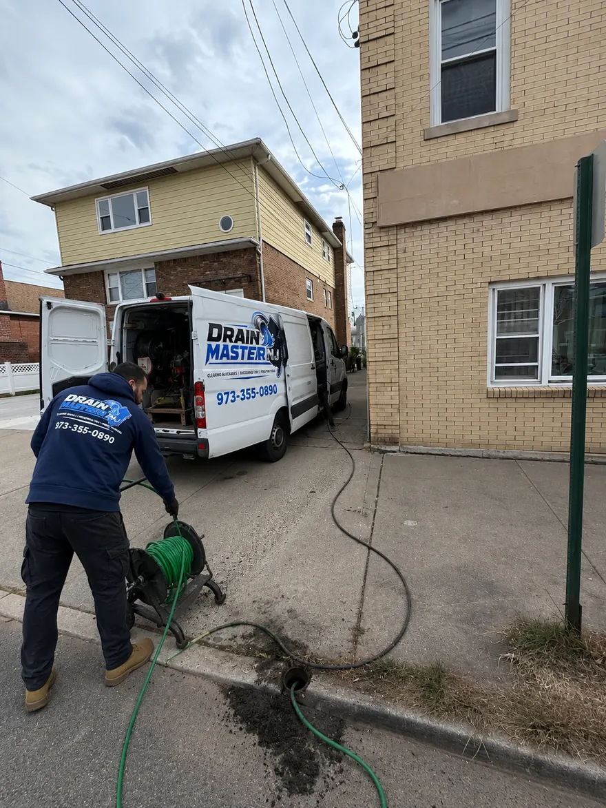 Pipe Descaling & Cast Iron Cleaning in New Jersey — Drain Master NJ Drain Master NJ technician running descaling equipment into a cast iron drain line through a cleanout in New Jersey