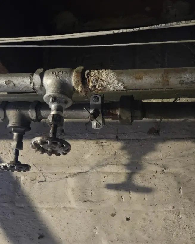 Decades-Old Iron Piping in a NJ Basement — Drain Master NJ Heavily corroded decades-old iron piping and valve in a New Jersey basement