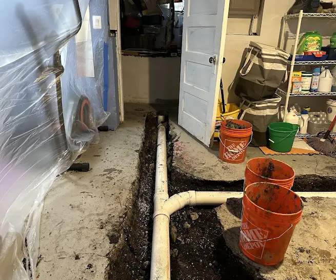 Interior Drain Work With Full Protection — Drain Master NJ New drain line installed through an interior trench at a New Jersey home with floors and belongings protected in plastic