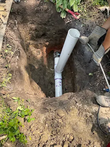 New PVC Sewer Lateral Installed — Drain Master NJ New white PVC sewer lateral and cleanout installed in a neatly excavated trench at a New Jersey home