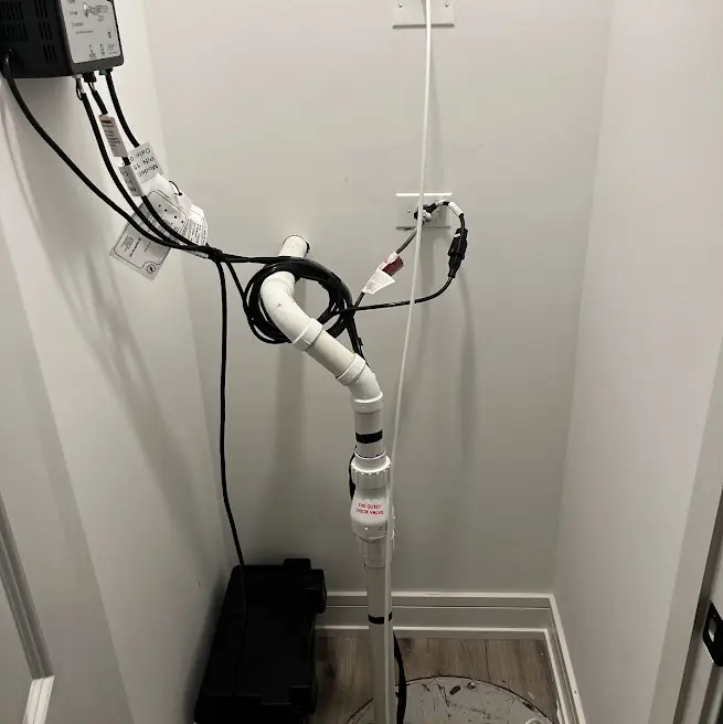 New sump ejector pump system with check valve and alarm installed in a New Jersey basement closet