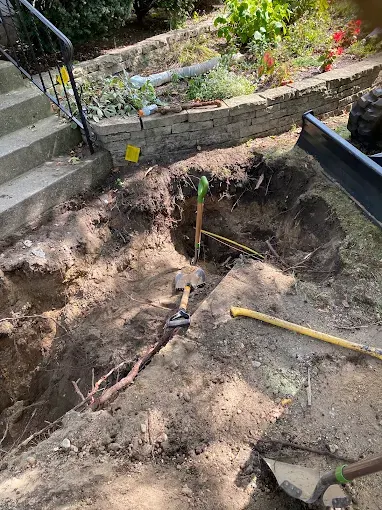 Careful Sewer Excavation Near Landscaping — Drain Master NJ Careful hand excavation of a sewer line beside garden steps and landscaping at a New Jersey home