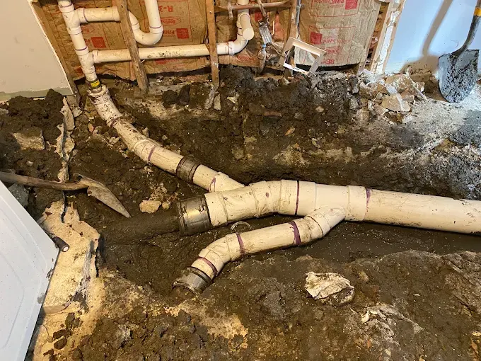 Under-Floor Pipe Section Replacement — Drain Master NJ New PVC drain piping joined to original cast iron with shielded couplings under a New Jersey basement floor