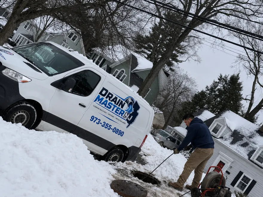 Drain Unclogging Service in New Jersey — Drain Master NJ Drain Master NJ technician unclogging a blocked drain line with professional snaking equipment at a New Jersey home